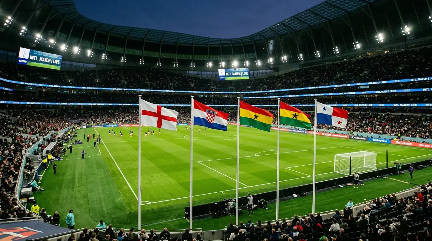 Grúpa L ag Corn an Domhain 2026 — páirc sacair le ceithre bhratach náisiúnta ag an taobhlíne