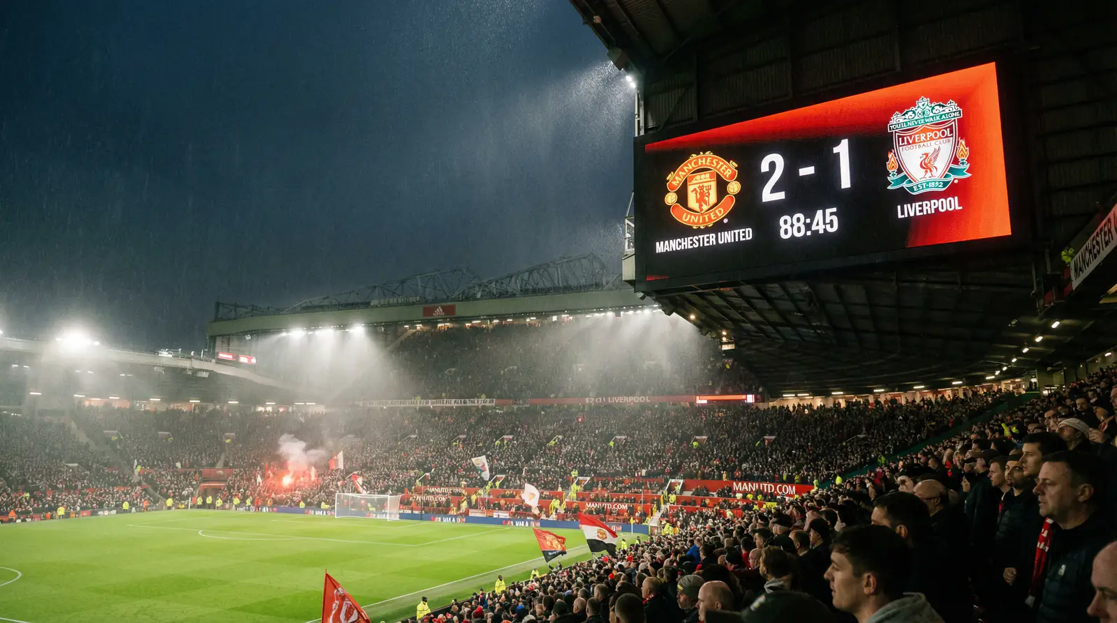 Scorthabla leictreonach ag staidiam sacair le sluaite ag breathnú ar an scór le linn cluiche oíche